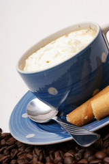 blaue tasse kaffee mit knusperröllchen und Sahne