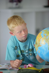 Portrait d'un petit garçon faisant tourner un globe