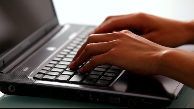Zoom sur des mains tapant sur un clavier d'ordinateur