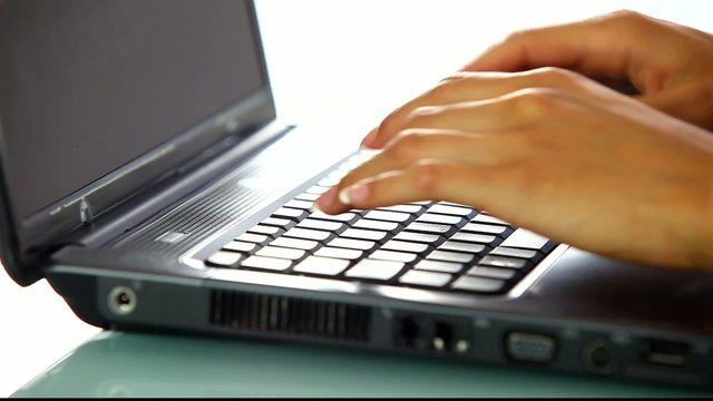 personne tapant sur un clavier d'ordinateur portable