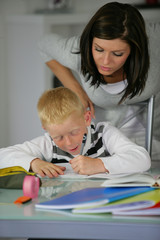 Portrait d'une femme aidant un petit garçon à faire ses devoirs