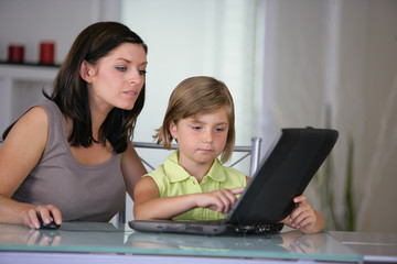 Fototapeta na wymiar femme et d'une petite fille devant un ordinateur portable