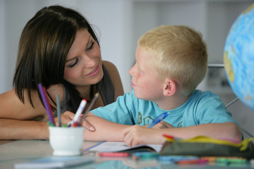 Obraz na płótnie Canvas Portrait d'une femme aidant un petit garçon à faire ses devoirs