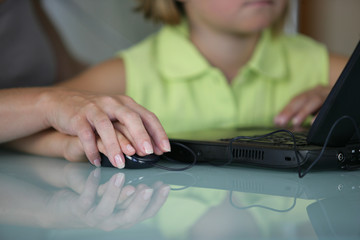 Femme aidant une enfant à se servir d'un ordinateur portable