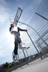 young businessman jumping on basket ball court