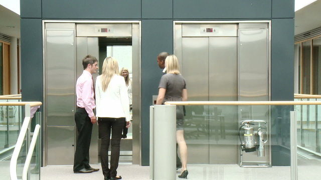 Business people using a lift in building footage