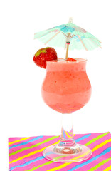 glass of strawberry smoothie with small parasol