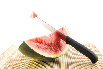 slice of a watermelon with a knife with piece of the watermelon