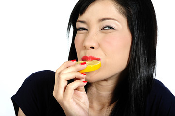 Young asian girl eating lemon