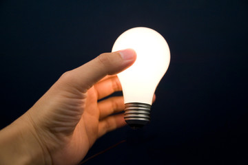 Hand holding a Bright Light Bulb