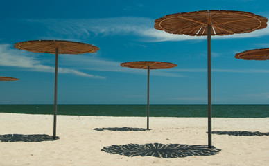 Fototapeta premium Wooden sun-covers at the sandy beach