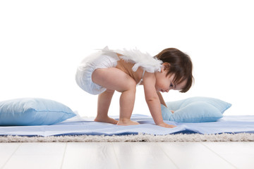 Little angel playing with pillows
