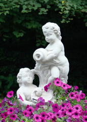 sculpture of children in a flowerbed from pink petunias