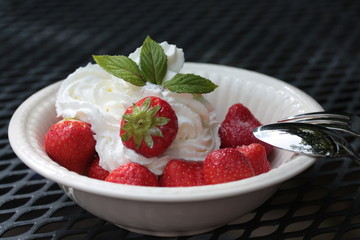 strawberries with cream, decorated with mint leaves