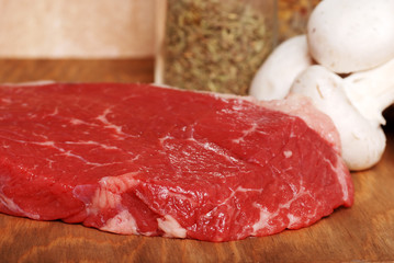 raw steak with mushrooms and seasoning
