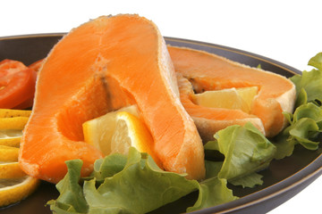 two salmon steak on dark dish