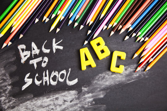 Colour pencils in vibrant tones on a blackboard