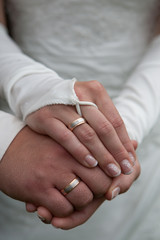 Hände von einem Hochzeitspaar mit Ring und Kleid