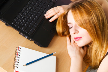 Young woman sleeping at her workplace