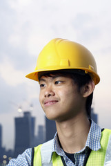 Young asian construction engineer wearing yellow hardhat