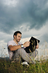 man with the laptop sitting in the field
