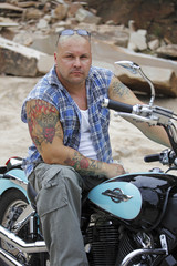 Biker with tattoo relaxing on his bike