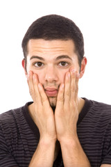 Portrait of a young angry man with hand at face on white