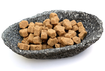 morceaux de sucre brun de canne dans coupelle de pierre