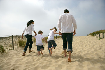 Famille marchant sur une dune de sable