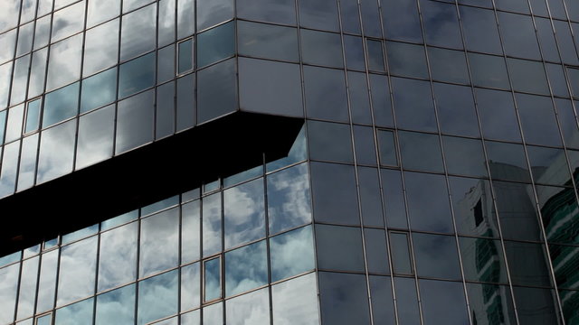 reflections of clouds in glass office tower, london