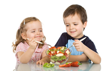 Happy kids eating fruit salad