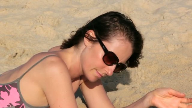 femme jouant avec le sable