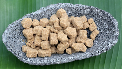 des morceaux de sucre roux dans coupelle de pierre