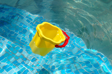 The children's bucket floats in pool