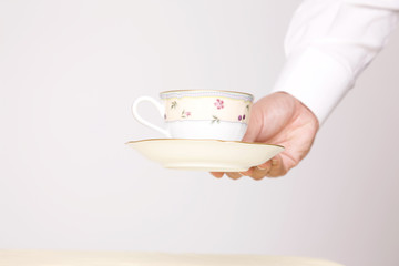 紅茶をテーブルに置くカフェ店員