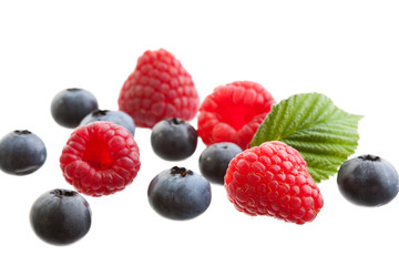 Raspberries and blueberries isolated on white background