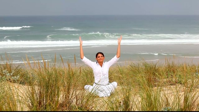 Femme m&eacute;ditant au bord de l'oc&eacute;an