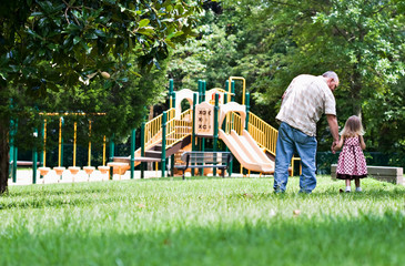 Father and daughter walking to the playground.