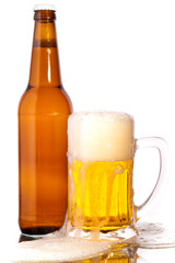 Glass of beer in the front with foam with bottle