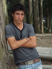 rapaz encostado a uma árvore