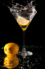 Splashing on martini with lemon isolated on dark