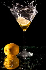 Foto op Canvas Spatten op martini met citroen geïsoleerd op donker © vaso