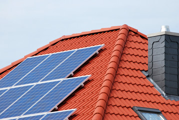 Bungalow mi Solarzellen und Schornstein