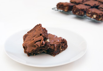 Two freshly baked brownies on white
