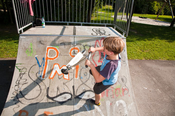 Kind fährt begeistert Roller im Skateboard Roller Park und übt
