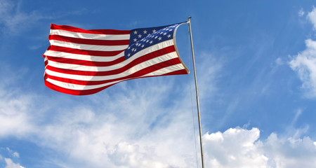 Waving American flag against a blue sky background