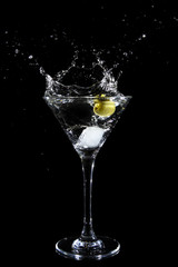 Splashing olive into a martini glass