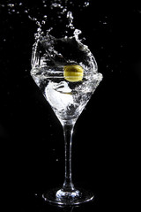 Splashing olive into a martini glass