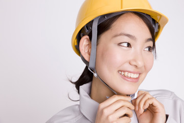 ヘルメットを被る女性作業員