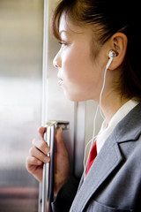 電車内で音楽を聴く女子高生